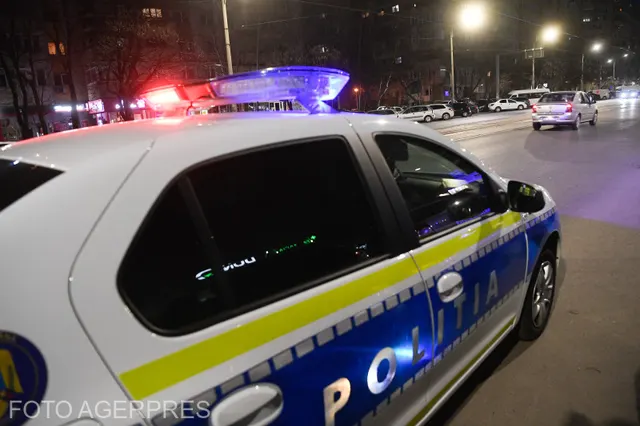 Autospecială a Poliției cu girofarul aprins, pe o stradă luminată, noaptea