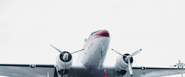 Avion cu elice și două motoare, fotografiat din față, pe un fundal alb