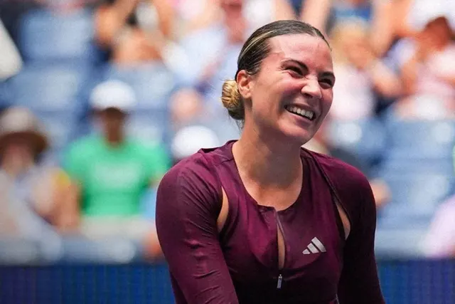 Jucătoare de tenis zâmbind, în tricou vișiniu Adidas, cu publicul în fundal