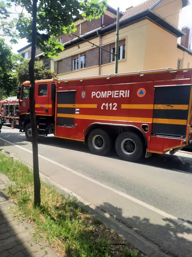 Autospecială de pompieri cu inscripția 112, oprită pe o stradă lângă o clădire
