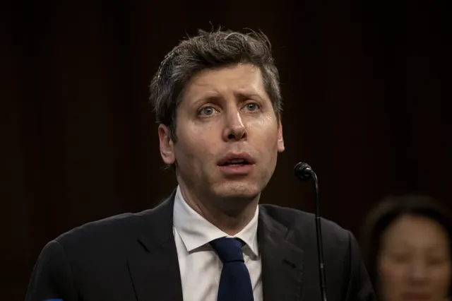 Sam Altman, în costum și cravată, în fața unui microfon, pe un fundal întunecat