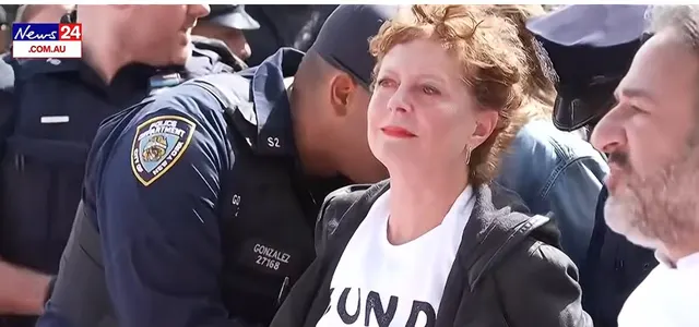Femeie cu părul roșcat, creț, condusă de polițiști din New York printr-o mulțime