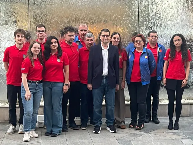 Echipa în tricouri roșii, alături de oficiali în costum, pozând în grup la Olimpiada de Șah