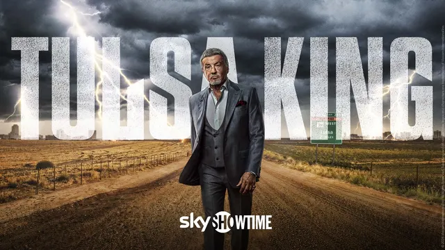 Afișul serialului „Tulsa King” pe SkyShowtime: bărbat în costum pe un drum de țară, sub un cer cu fulgere