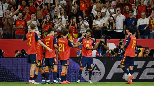 Fotbaliști în echipamentul roșu al Spaniei sărbătorind împreună în fața unei tribune pline