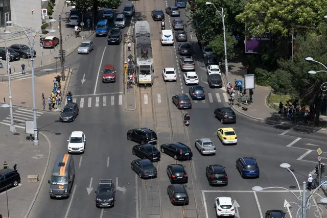 Intersecție aglomerată văzută de sus, cu șiruri de mașini și un autobuz pe bulevard