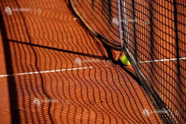 Fileul unui teren de tenis cu zgură, cu umbra plasei și o minge lângă fileu