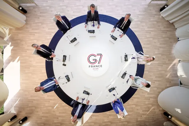 Lideri așezați la o masă rotundă, fotografiați de sus, cu sigla G7 France în centru