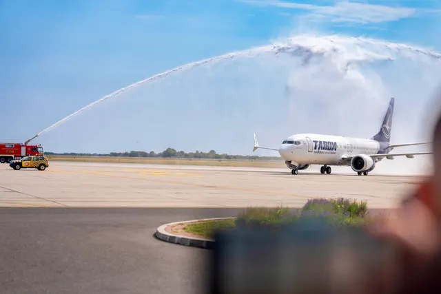 Avion TAROM salutat cu jeturi de apă de mașinile de pompieri, pe pista aeroportului