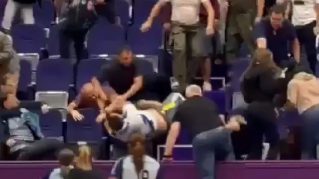 Încăierare în tribunele unei săli de sport: oameni care se îmbrâncesc printre scaunele violet