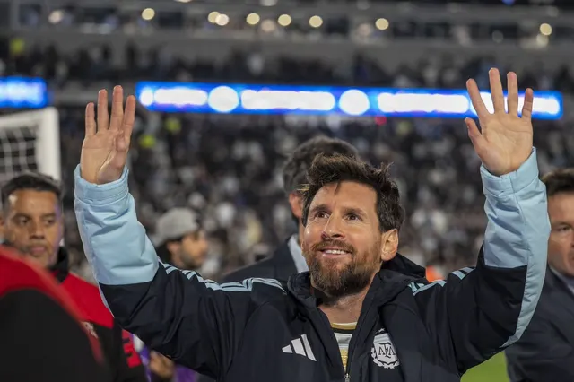 Fotbalist cu barbă, în trening al naționalei Argentinei, salutând cu ambele mâini publicul de pe stadion