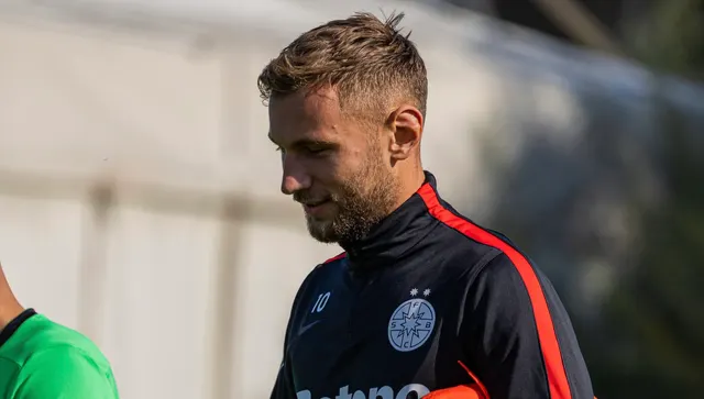 Fotbalist în bluza de antrenament a FCSB, cu privirea în jos, pe marginea terenului