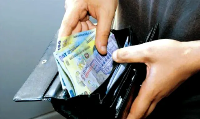 Mână care scoate bancnote românești dintr-un portofel negru