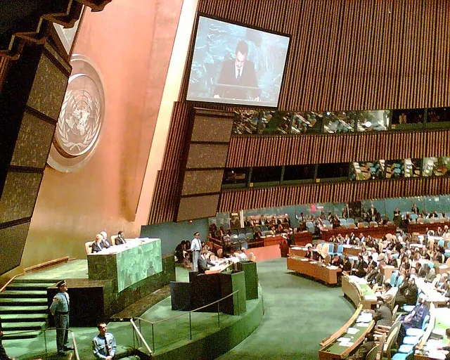 Sala Adunării Generale a ONU de la New York, cu delegații în bănci și emblema ONU