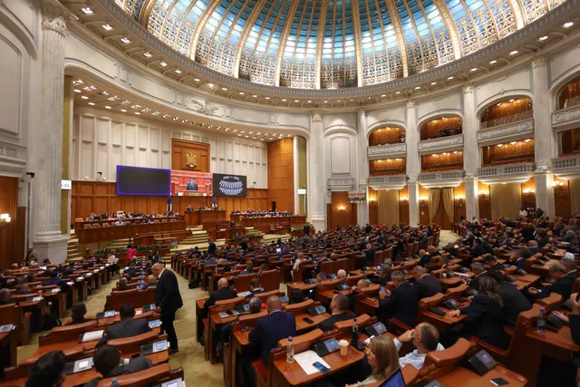 Sala de plen a Camerei Deputaților din Palatul Parlamentului, cu cupola de sticlă și parlamentari în bănci