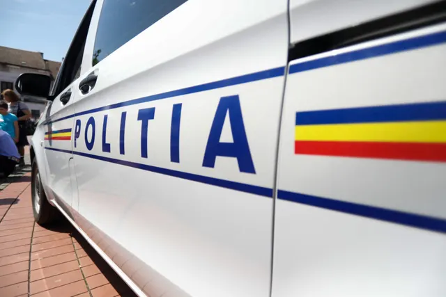 Mașină de poliție albă, cu inscripția „POLIȚIA” și banda tricoloră pe lateral